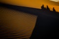 Shadows of Three People Ã¢â¬â Climbing Big Daddy Dune at Sunrise Royalty Free Stock Photo